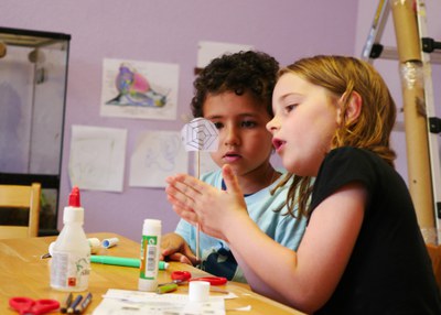 Zwei Kinder mit selbst gebastelter Drehscheibe