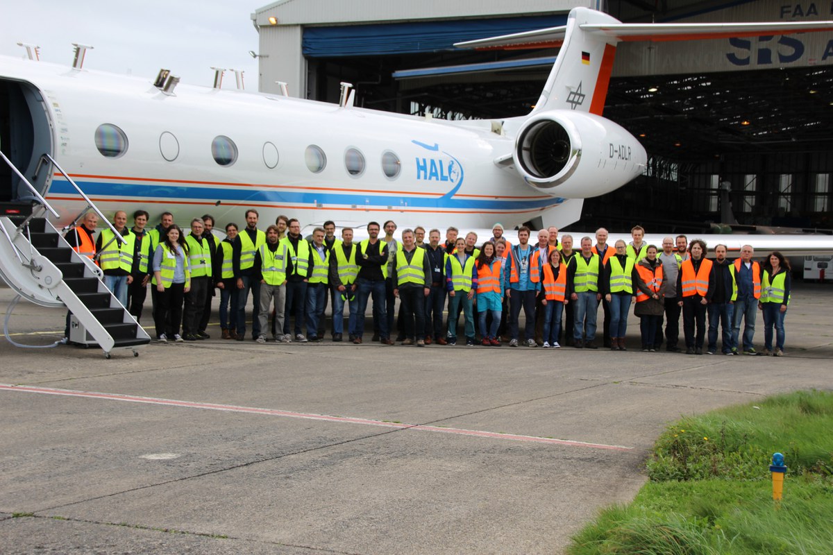 Kampagnen-Team neben dem Flugzeug im Hangar