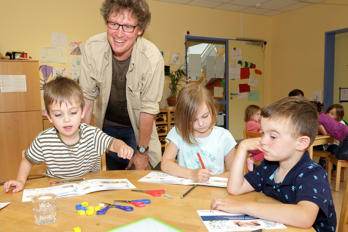Kinder beschäftigen sich an einem Tisch mit einem Thema