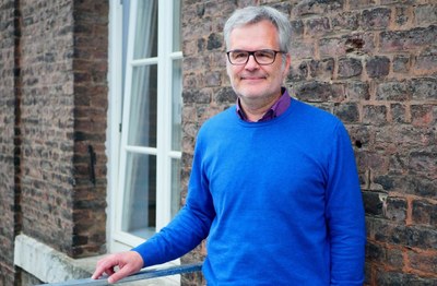 Prof. Hans Ekkehard Plesser im Halbformat stehend vor einer Hauswand.