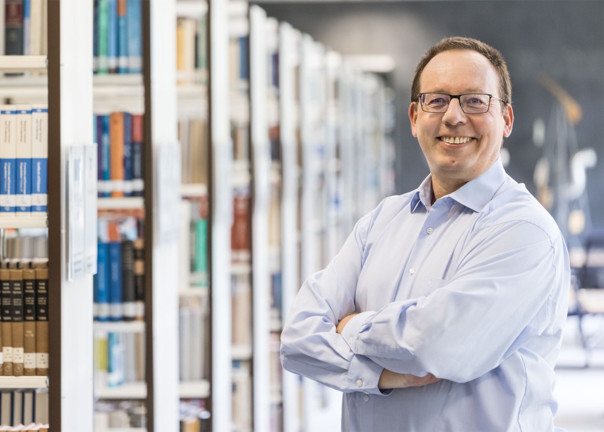 Bernhard Mittermaier steht in der Bibliothek.