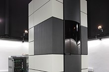 Ein modernes Gebäude mit großen Glasflächen und einer beleuchteten Fassade bei Nacht. (Mistral: Pixtral Large 2411, 2026-03-04)