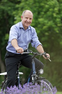 Peter Burauel mit dem Fahrrad unterwegs auf dem Campus.