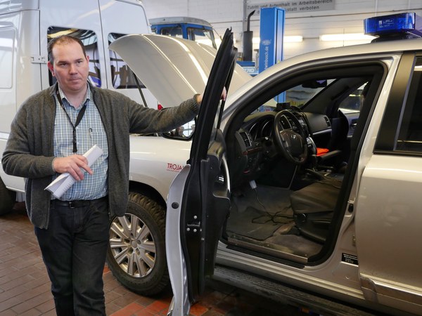 Ricardo Gatzweiler vor dem gepanzerten Schutzfahrzeuge. Quelle: Forschungszentrum Jülich