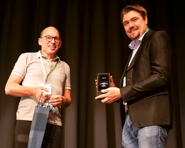 Prof. Dr. Andreas Reif (links), Vorstandsmitglied der DGBS, überreicht Jun.-Prof. Dr. Andreas Forstner (rechts) den Jules Angst Forschungspreis 2022.