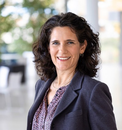 Julia Dreher is standing portrait and smiling into the camera.