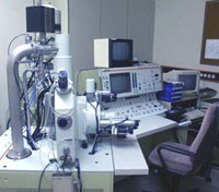A laboratory setup with multiple electronic devices, a chair, and various equipment on a table. (Mistral: Pixtral Large 2411, 2026-03-05)