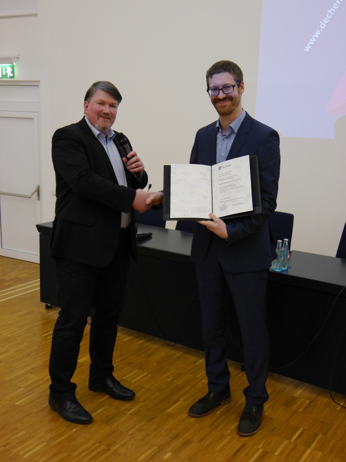 Der Vorsitzende der DECHEMA-Fachgemeinschaft Biotechnologie, Prof. Dr. Roland Ulber, überreicht den DECHEMA-Hochschullehrer-Nachwuchspreis für Biotechnologie an Jun.-Prof. Dr. Alexander Grünberger
