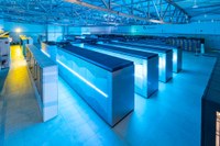 A large, well-lit room with multiple illuminated server racks and overhead lighting. (Mistral: Pixtral Large 2411, 2026-03-23)