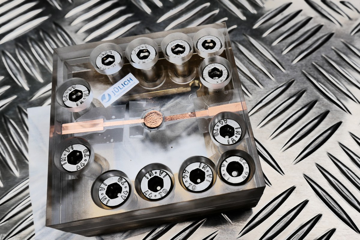 Testaufbau für die Festkörperbatterie: Die Batterie von der Größe einer Knopfzelle befindet sich in der Mitte des Plexiglasgehäuses.